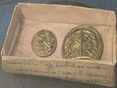 Des boutons pris sur l'uniforme que portait sur le radeau l'aspirant de 1re classe Coudein sont expos&eacute;s - - &copy; Service historique de la D&eacute;fense